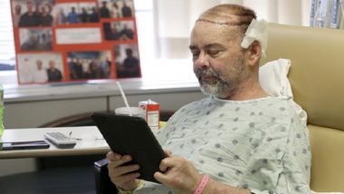 In this photo taken on Wednesday, June 3, 2015, James Boysen reads messages in his hospital bed at Houston Methodist Hospital, in Houston. Boysen received the world's first skull and scalp transplant to help heal a large head wound from cancer treatment. (AP Photo/Pat Sullivan)