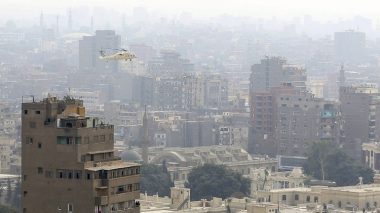 A reconnaissance military helicopter flies over Cairo